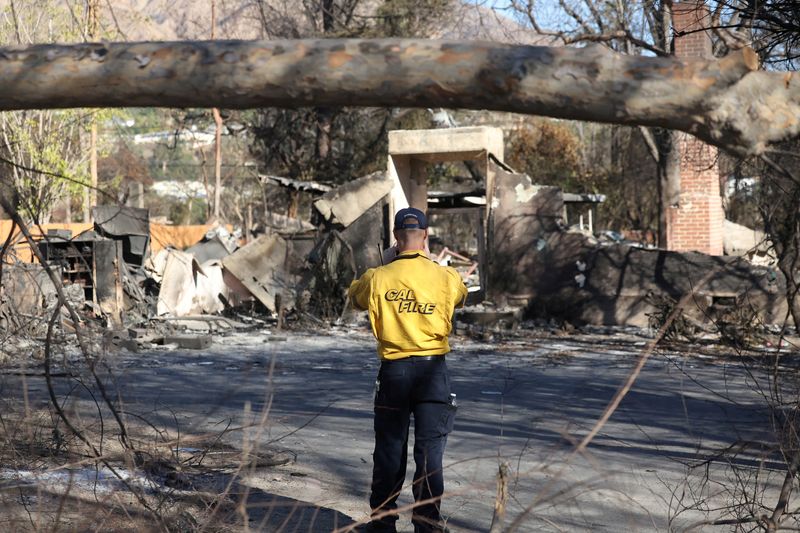 &copy; Reuters. FILE PHOTO: A CalFire personnel takes photos of a structure burned during the Eaton fire in Pasadena, California, U.S., January 15, 2025. REUTERS/Mario Anzuoni/File Photo