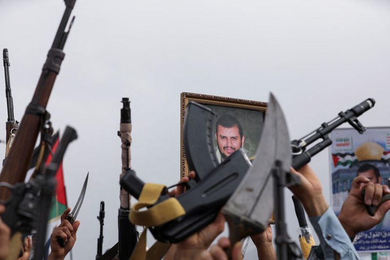 © Reuters. FILE PHOTO: A poster of Houthi leader, Abdul Malik al-Houthi, is held by a protester as others hold up their weapons during a rally held to show support to Palestinians in the Gaza Strip, amid Israel-Hamas conflict, in Sanaa, Yemen July 26, 2024. REUTERS/Khaled Abdullah/File Photo