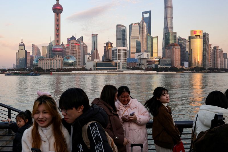 © Reuters. People hang out at The Bund as the Pudong financial district appears in the background in Shanghai, China, January 16, 2025. REUTERS/Joe Nakamura   