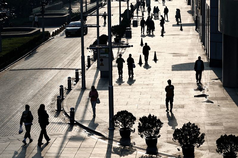 &copy; Reuters. FILE PHOTO: People walk past an office and shopping complex in Beijing, China April 10, 2024. REUTERS/Tingshu Wang/File Photo