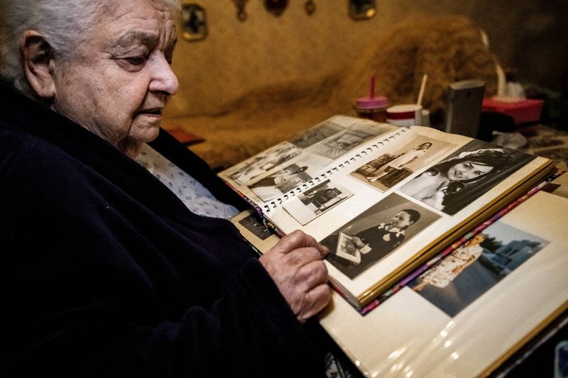 &copy; Reuters. Hungarian Auschwitz survivor Agnes Darvas, 92, looks at photographs of her younger years in an album in her apartment in Budapest, Hungary, January 9, 2025. REUTERS/Marton Monus