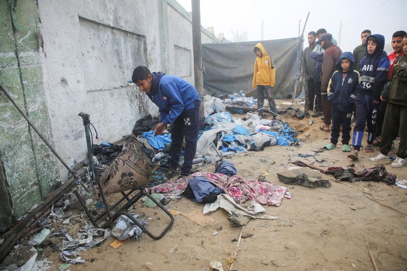 © Reuters. Palestinian boys inspect the damage to a tent for displaced people, after an Israeli airstrike, amid the conflict between Israel and Hamas, in Khan Younis, southern Gaza Strip, January 17, 2025. REUTERS/Hatem Khaled