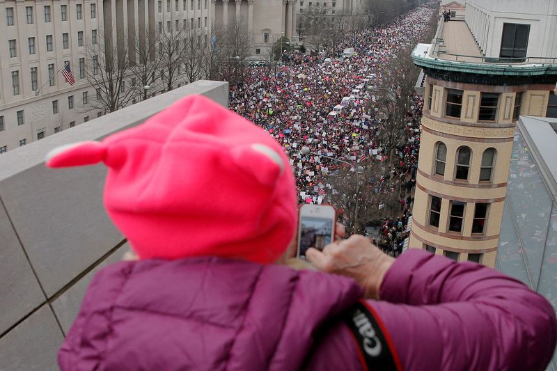 &copy; Reuters. FILE PHOTO: A woman wearing a pink pussy protest hat takes a photograph of the Women's March on Washington, following the inauguration of U.S. President Donald Trump, in Washington, DC, U.S. January 21, 2017.   REUTERS/Brian Snyder/File Photo