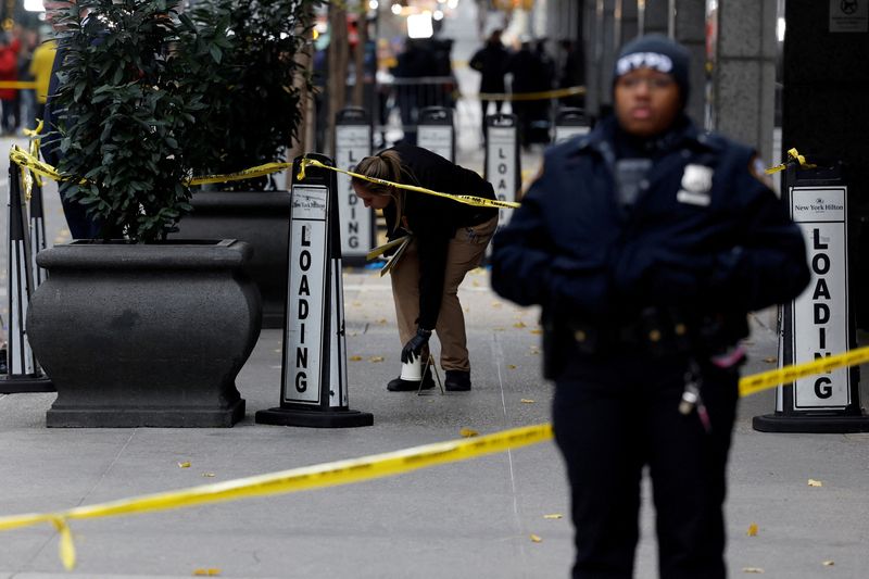 &copy; Reuters. FILE PHOTO: A member of the NYPD Crime Scene Unit works near evidence markers placed where shell casings were found at the scene where the CEO of UnitedHealthcare Brian Thompson was reportedly shot and killed in Midtown Manhattan, in New York City, US, De