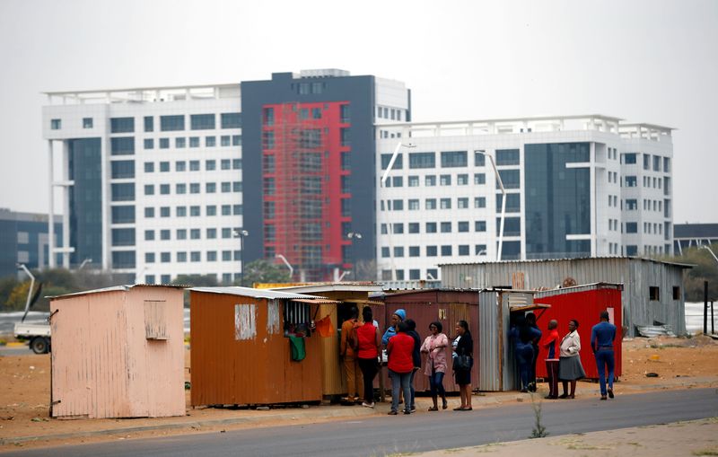 © Reuters. FILE PHOTO: Local workers queue to buy food at a makeshift food shops near a construction site of the Central Business District (CBD) in the capital Gaborone, Botswana, September 21, 2018. REUTERS/Siphiwe Sibeko/File Photo