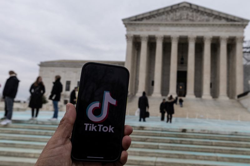 &copy; Reuters. The TikTok logo is displayed on a mobile phone next to the U.S. Supreme Court, in this picture illustration taken January 17, 2025. REUTERS/Carlos Barria/Illustration