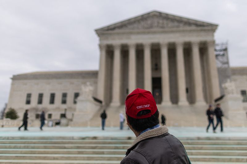 © Reuters. A supporter of U.S. President-elect Donald Trump stands outside the U.S. Supreme Court, in Washington, U.S., January 17, 2025. REUTERS/Carlos Barria