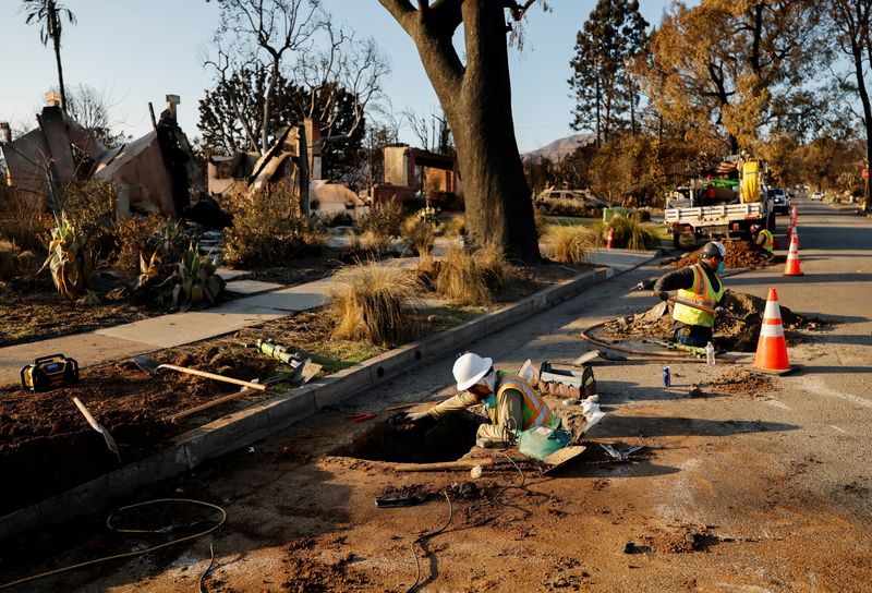 © Reuters. Utility workers work to restore a gas line near homes burnt by the Palisades Fire, in Pacific Palisades, California, U.S., January 17, 2025. REUTERS/Fred Greaves