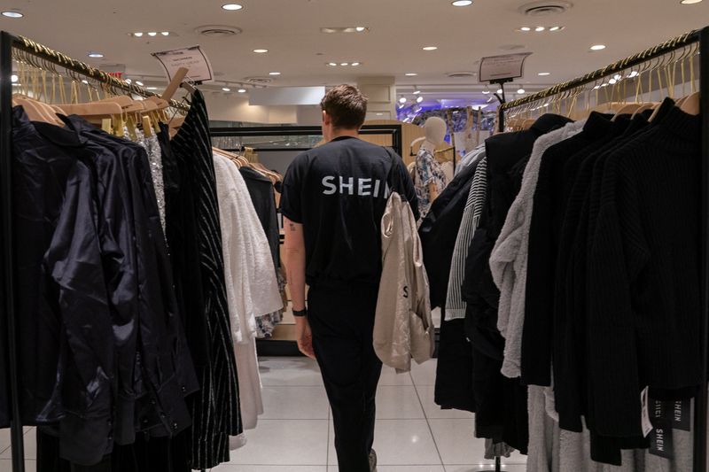 © Reuters. FILE PHOTO: An employee at the Shein Holiday pop-up shop inside of Times Squares Forever 21 in New York City, U.S., November 10, 2023.REUTERS/David 'Dee' Delgado/File Photo
