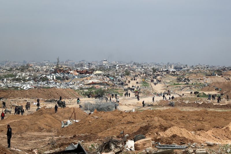 © Reuters. Palestinians make their way after Israeli forces withdrew from the Netzarim Corridor, allowing people to travel in both directions between southern and northern Gaza, amid a ceasefire between Israel and Hamas, near Gaza City, February 9, 2025. REUTERS/Dawoud Abu Alkas