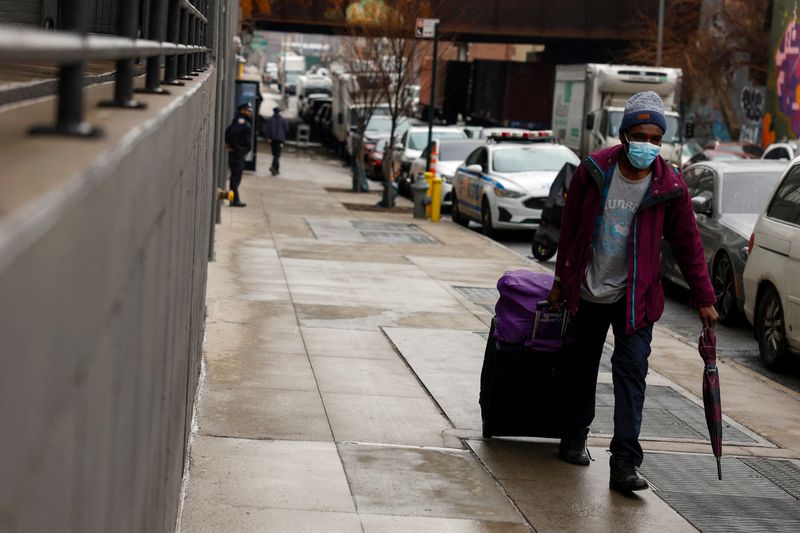 © Reuters. FILE PHOTO: A man walks with his belongings before entering a new 2,200-bed migrant men’s shelter in the Bronx borough of New York City, U.S., February 27, 2025. REUTERS/Shannon Stapleton/File Photo