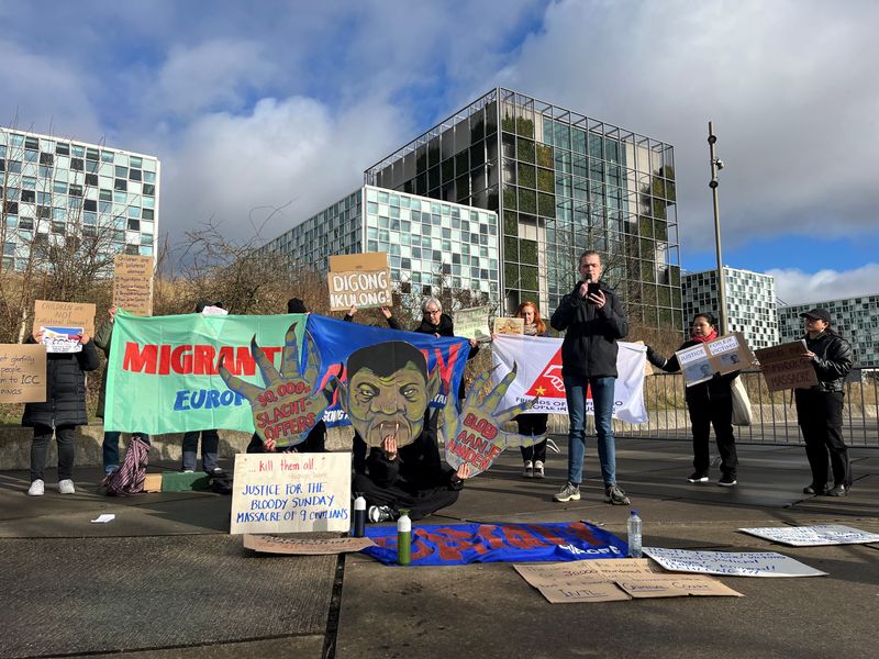 © Reuters. People from the Filipino community in the Netherlands hold banners during a protest against former Philippine President Rodrigo Duterte, in front of the ICC in the Hague, Netherlands March 12, 2025. REUTERS/Marta Fiorin