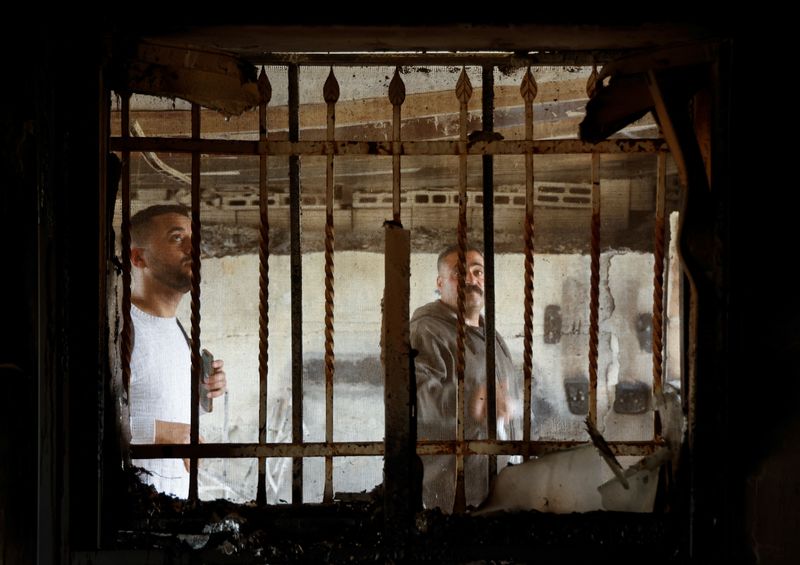 &copy; Reuters. Palestinians look at a window of a damaged building, following an Israeli settlers' attack, near Duma in Nablus, in the Israeli-occupied West Bank, March 14, 2025. REUTERS/Raneen Sawafta/File Photo