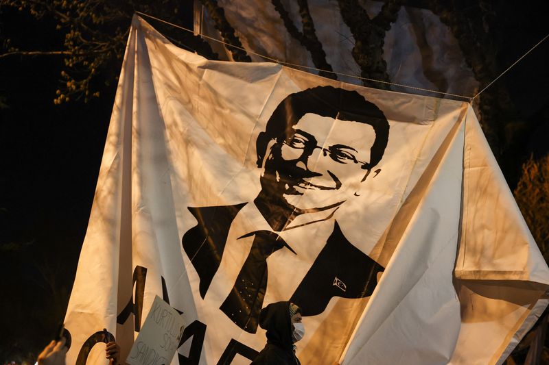 &copy; Reuters. A person walks past a banner with an image of Istanbul Mayor Ekrem Imamoglu, as people take part in a protest against the detention of Imamoglu, in Istanbul, Turkey, March 20, 2025. REUTERS/Umit Bektas