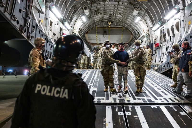 &copy; Reuters. FILE PHOTO: U.S. military personnel escort alleged members of the Venezuelan gang Tren de Aragua and the MS-13 gang recently deported by the U.S. government to be imprisoned in the Terrorism Confinement Center (CECOT) prison, at the El Salvador Internatio