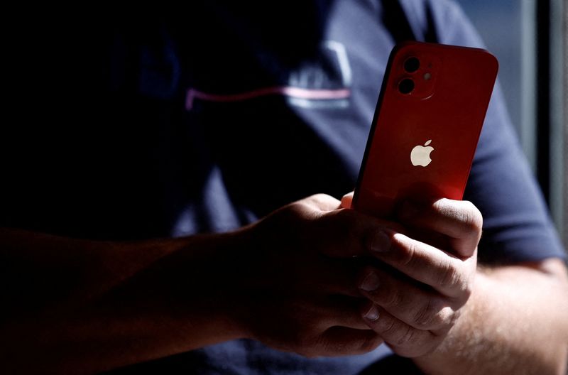 &copy; Reuters. FILE PHOTO: A man poses with an Apple iPhone 12 in a mobile phone store in Nantes, France, September 13, 2023. REUTERS/Stephane Mahe/File photo