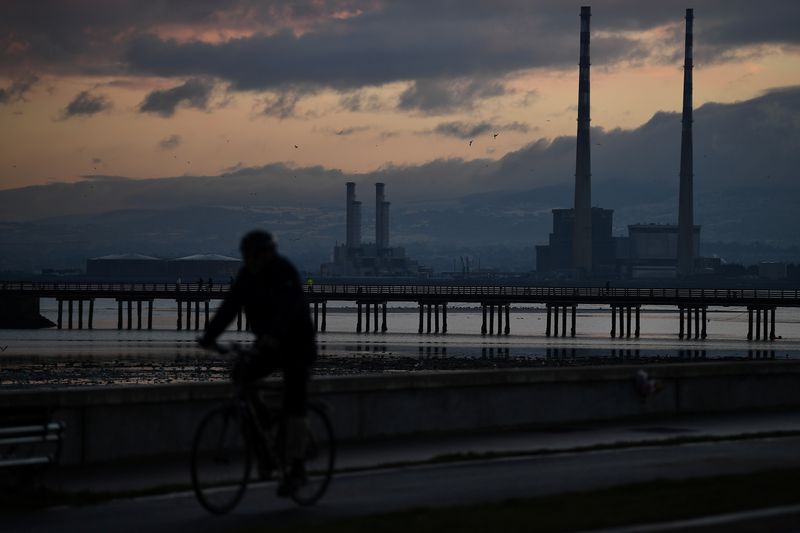 &copy; Reuters. FILE PHOTO: A man cycles along Clontarf Promenade with Dublin Port seen at sunset in Dublin, Ireland, January 24, 2021. Picture taken January 24, 2021. REUTERS/Clodagh Kilcoyne/File Photo