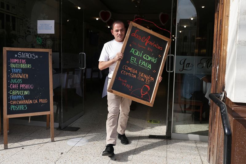 &copy; Reuters. Homem segura quadro que diz: "O Papa comeu aqui. Comida abençoada, comida com fé", do lado de fora do restaurante "Las Américas", em Chiclayon09/05/2025nREUTERS/Sebastian Castaneda
