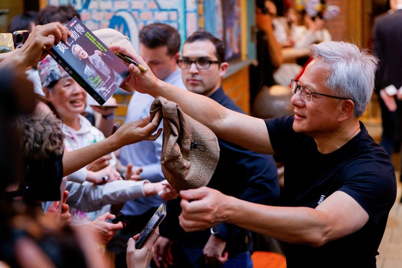 &copy; Reuters. CEO da Nvidia, Jensen Huang, cumprimenta fãs e membros da imprensa do lado de fora de um restaurante em Taipé, Taiwann17/5/2025 REUTERS/Ann Wang/Arquivo