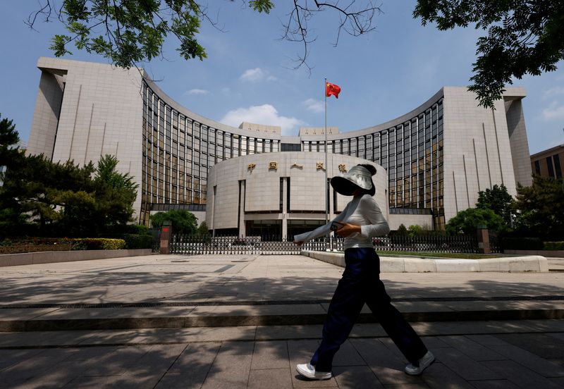 © Reuters. ẢNH TƯ LIỆU: Một người đi ngang trụ sở Ngân hàng Nhân dân Trung Quốc, ở Bắc Kinh, Trung Quốc ngày 7 tháng 5 năm 2025. REUTERS/Tingshu Wang/ Ảnh Tư liệu 