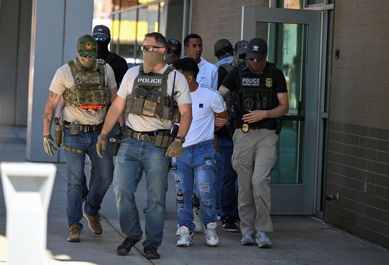 &copy; Reuters. FILE PHOTO: Law enforcement officers, including HSI and ICE agents, take people into custody at an immigration court in Phoenix, Arizona, U.S., May 21, 2025.  REUTERS/Caitlin O'Hara/File Photo