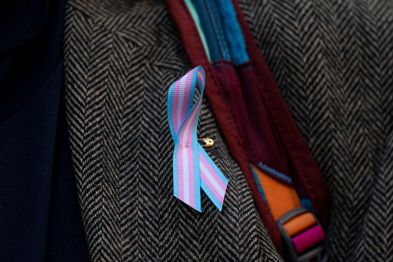 &copy; Reuters. FILE PHOTO: A supporter wears a pro-trans ribbon after a hearing in the multi-state lawsuit over President Trump's order ending all federal funding or support for healthcare that aids gender transitions for people younger than 19, outside a courthouse in