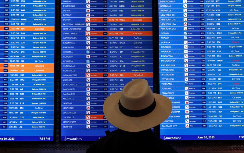 &copy; Reuters. FILE PHOTO: Travelers check the status of their flights at Ronald Reagan Washington National Airport in Arlington, Virginia, U.S., June 30, 2023. REUTERS/Evelyn Hockstein/File Photo