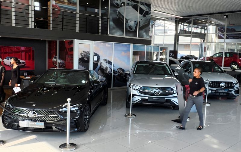 &copy; Reuters. FILE PHOTO: A person walks past Mercedes-Benz cars on display at a showroom in Johannesburg, South Africa March 6, 2025. REUTERS/Siphiwe Sibeko/File Photo