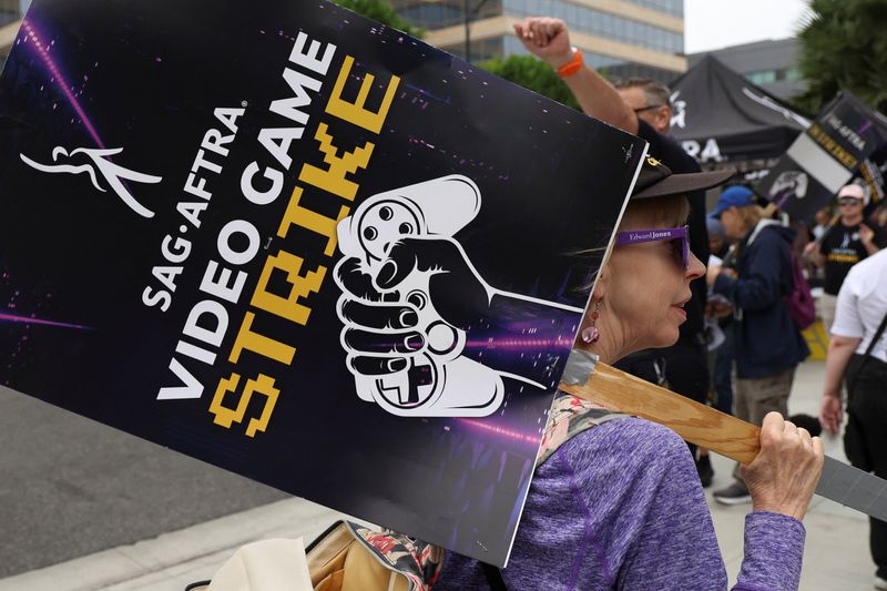 &copy; Reuters. A person holds a sign as she takes part in a SAG-AFTRA Video Game Strike picket outside Warner Bros. Games in Burbank, California, U.S. October 16, 2024.  REUTERS/Mario Anzuoni/File Photo