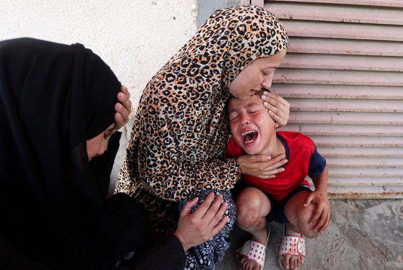 &copy; Reuters. A Palestinian woman comforts a child as casualties are brought into Al-Aqsa Martyrs Hospital following an Israeli strike, in Deir al-Balah, central Gaza Strip, July 10, 2025. REUTERS/Ramadan Abed      TPX IMAGES OF THE DAY