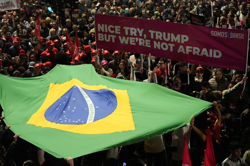 &copy; Reuters. FILE PHOTO: People hold a Brazilian flag as demonstrators protest U.S. President Donald Trump's announcement of 50% tariffs on Brazilian products, in Sao Paulo, Brazil, on July 10, 2025. REUTERS/Alexandre Meneghini/File Photo