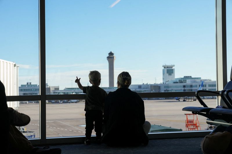 &copy; Reuters. FILE PHOTO: The air traffic control tower is seen from the gate as a woman and a child look out at the Denver International Airport terminal, in Denver, Colorado, U.S., May 15, 2025.  REUTERS/Megan Varner/File Photo
