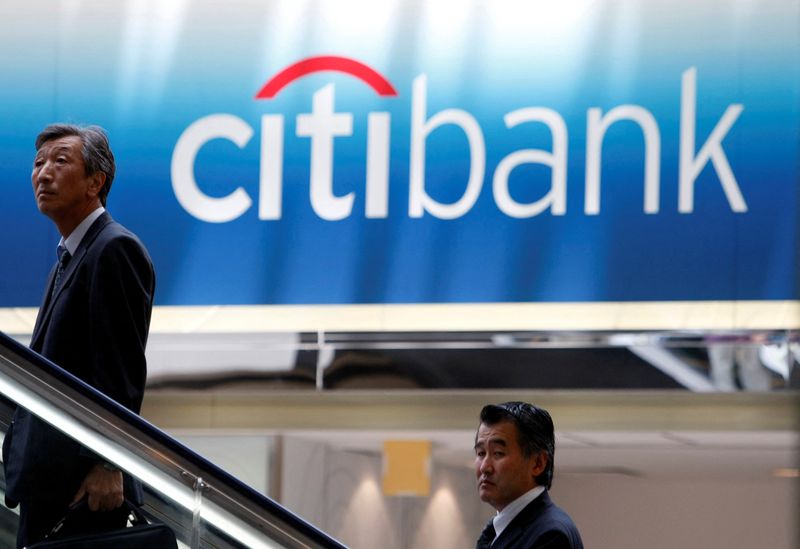 &copy; Reuters. FILE PHOTO: Men travel on an escalator near a Citibank signboard in Tokyo June 26, 2009. REUTERS/Kim Kyung-Hoon/File Photo