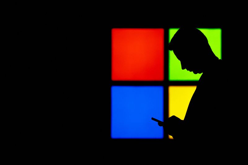 &copy; Reuters. Um homem olha para seu telefone enquanto passa pelo estande da Microsoft na feira Mobile World Congress, em Barcelona, Espanha, em 3 de março de 2025. REUTERS/ Bruna Casas