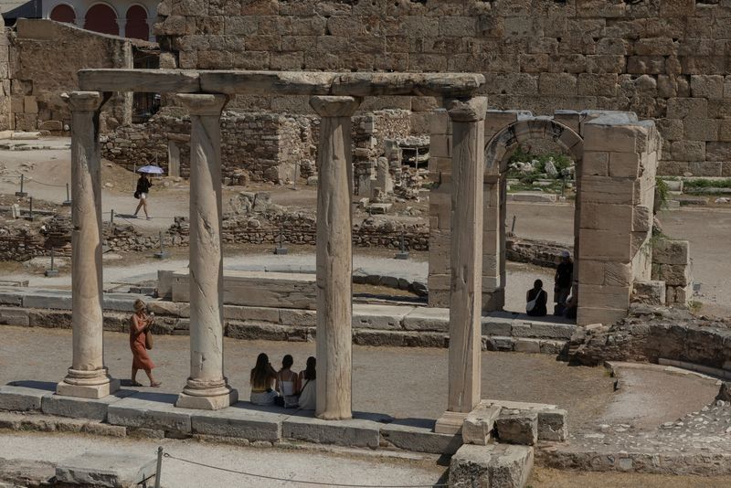 &copy; Reuters. Turistas visitam sítio arqueológico da Biblioteca de Adriano durante onda de calor em Atenas, Grécian22/07/2025nREUTERS/Louiza Vradi