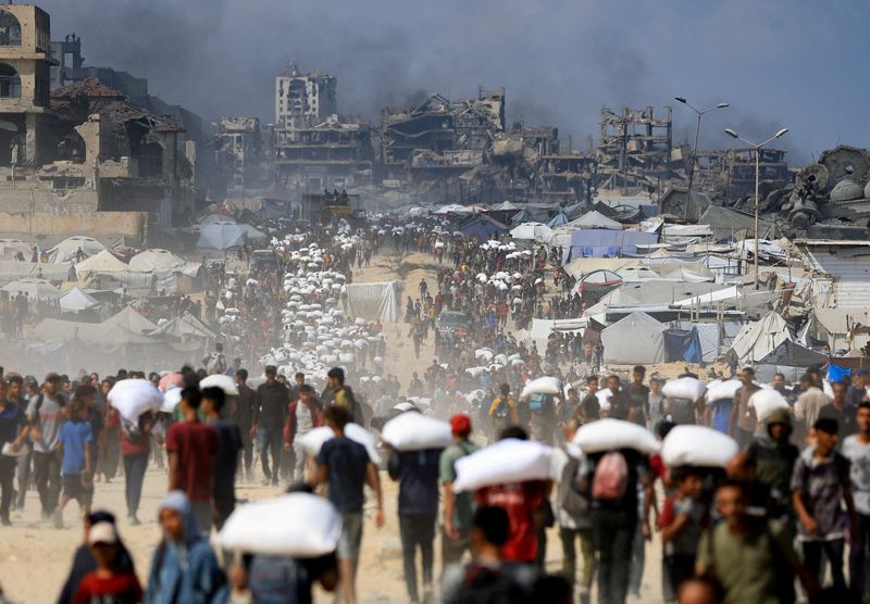 &copy; Reuters. Palestinos se reúnem para receber suprimentos em meio à fome em Beit Lahia, norte da Faixa de Gazan20/07/2025 REUTERS/Dawoud Abu Alkas
