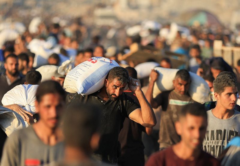 &copy; Reuters. Palestinos carregam ajuda em Beit Lahia, norte de Gazan 30/7/2025   REUTERS/Dawoud Abu Alkas