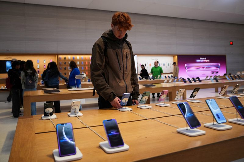 &copy; Reuters. FILE PHOTO: A person looks at iPhones in the Apple Fifth Avenue store in New York City, U.S., May 23, 2025. REUTERS/Adam Gray/File Photo