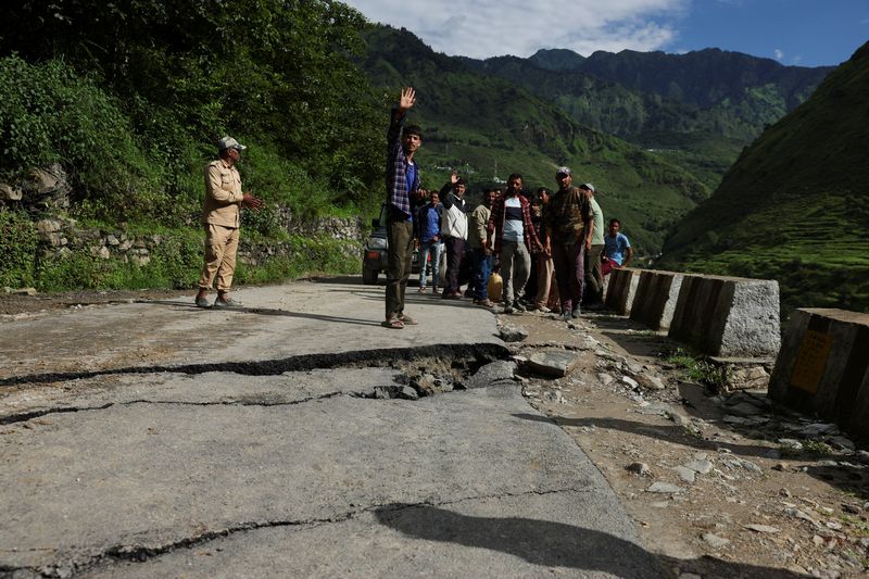 &copy; Reuters. Pessoas em via danificada após deslizamento de terra em Uttarakhand, na Índian 7/8/2025   REUTERS/Francis Mascarenhas