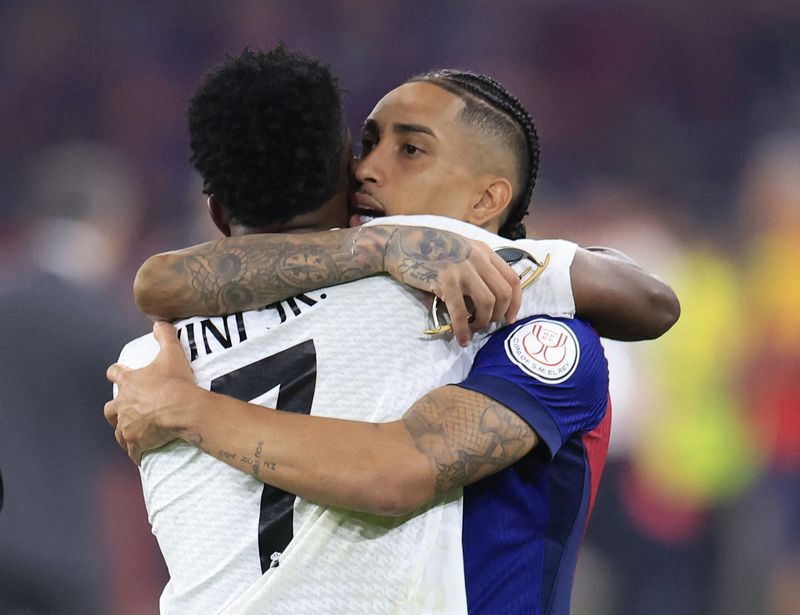 &copy; Reuters. Raphinha abraça Vinícius Jr em jogo Barcelona x Real Madridn 27/4/2025     REUTERS/Borja Suarez