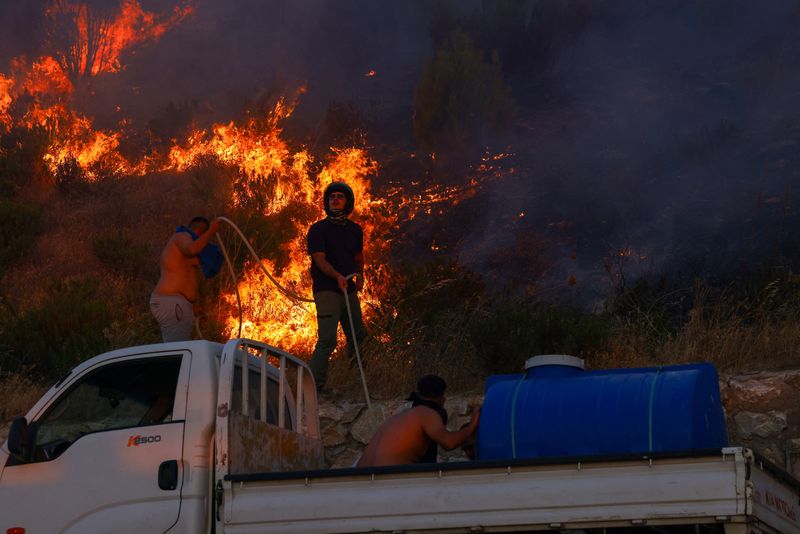 &copy; Reuters. Pessoas tentam extinguir incêndio florestal na cidade de Canakkale, na Turquian11/08/2025nREUTERS/Dilara Senkaya