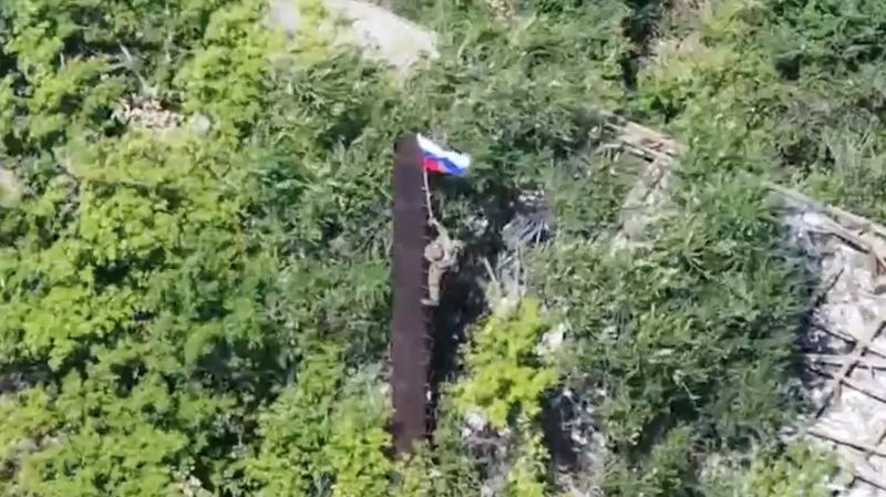 &copy; Reuters. Imagem de vídeo divulgado pelo Ministério da Defesa da Rússia mostra o que seria um soldado russo hasteando bandeira em Yablunivka, na região de Donetskn 12/8/2025    Divulgação via REUTERS