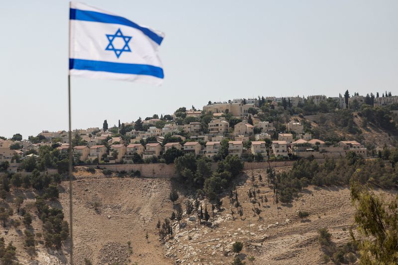 &copy; Reuters. Bandeira israelense na Cisjordânia ocupada por Israel com assentamento Maale Adumim ao fundon 14/8/2025    REUTERS/Ronen Zvulun