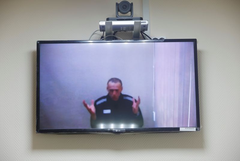 © Reuters. Russian opposition leader Alexei Navalny is seen on a screen via a video link during a hearing to consider his lawsuits against the penal colony over detention conditions there, at the Petushki district court in Petushki, Russia May 26, 2021. REUTERS/Maxim Shemetov