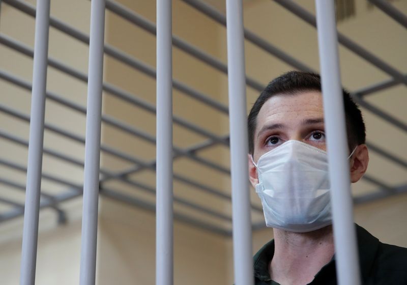 &copy; Reuters. FILE PHOTO: Former U.S. Marine Trevor Reed, who was detained in 2019 and accused of assaulting police officers, stands inside a defendants' cage during a court hearing in Moscow, Russia July 30, 2020. REUTERS/Maxim Shemetov