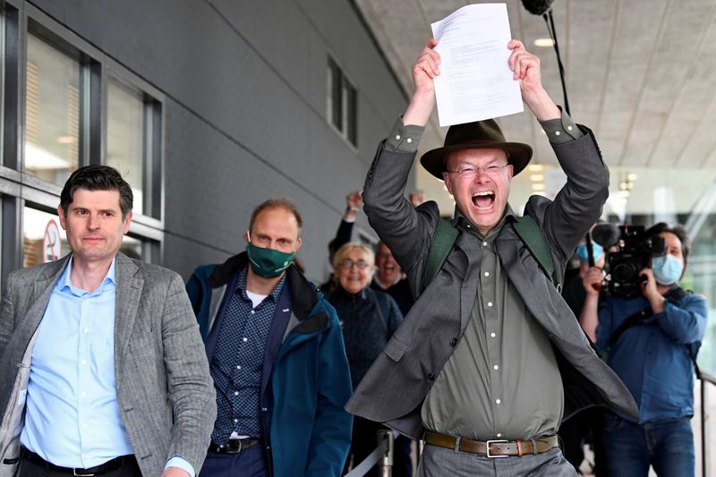 © Reuters. Donald Pols, Director of Milieudefensie (Friends of the Earth), reacts holding a copy of a verdict in a case brought on against Shell by environmentalist and human rights groups, including Greenpeace and Friends of the Earth, who demand the energy firm to cut its reliance on fossil fuels, in The Hague, Netherlands, May 26, 2021. REUTERS/Piroschka van de Wouw