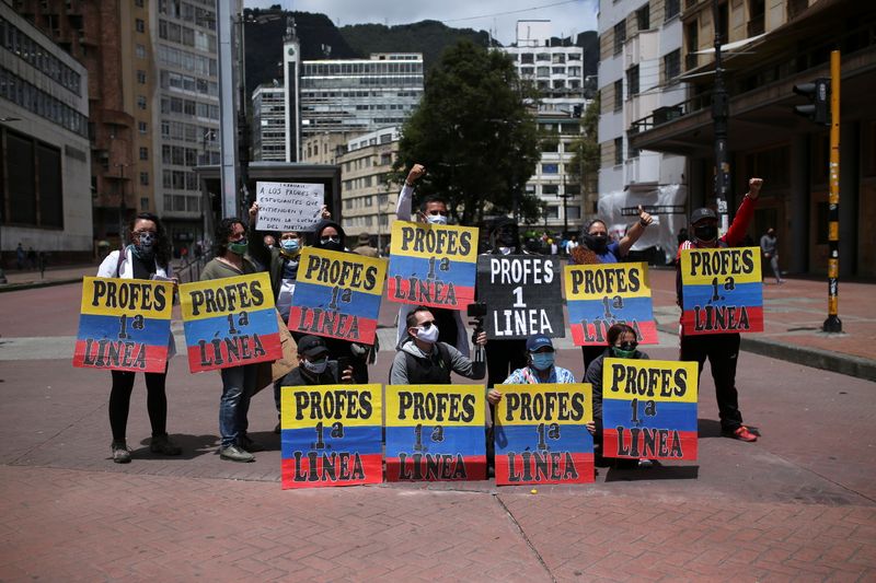 &copy; Reuters. People display signs during a protest demanding government action to tackle poverty, police violence and inequalities in healthcare and education systems, in Bogota, Colombia May 26, 2021. The signs read: "Teachers of the first line". REUTERS/Luisa Gonzal