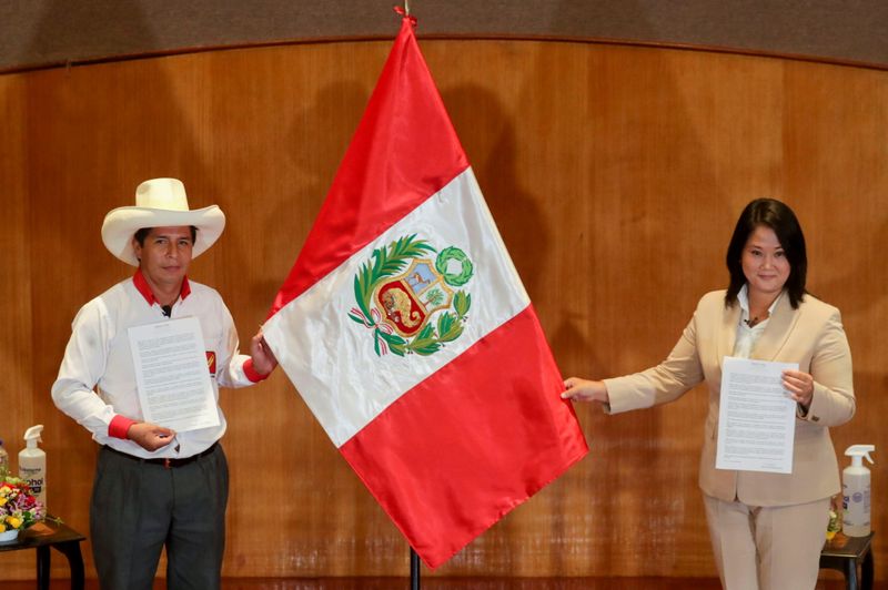 &copy; Reuters. FILE PHOTO: Peruvian presidential candidates Pedro Castillo and Keiko Fujimori, who will face each other in a run-off vote on June 6, hold Peru's national flag after signing a "Pact for Democracy," in Lima, Peru May 17, 2021. REUTERS/Sebastian Castaneda