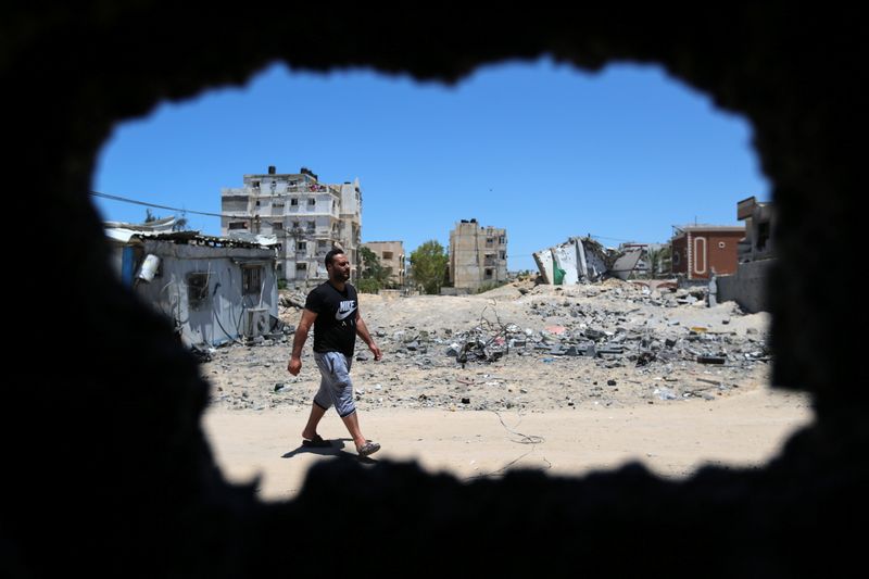 &copy; Reuters. Palestino caminha em meio a destroços em Gaza
24/05/2021
REUTERS/Ibraheem Abu Mustafa