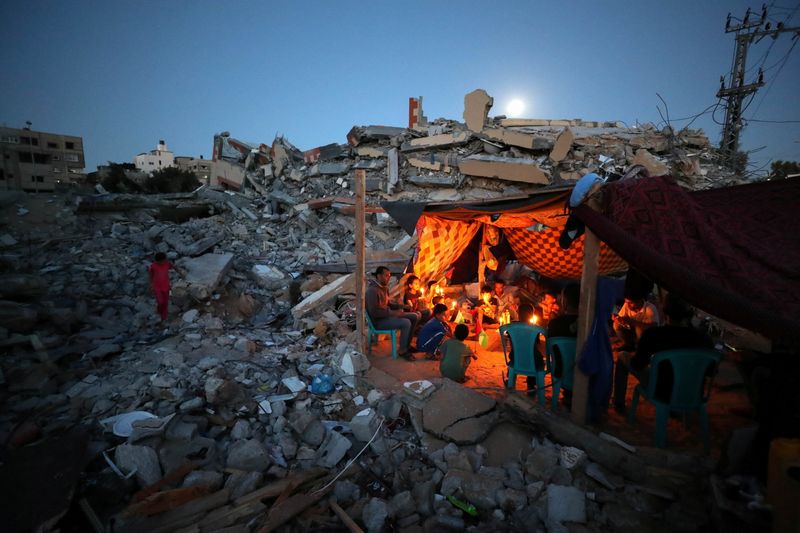 &copy; Reuters. فلسطينيون من عائلة الزوارعة و سط أنقاض منزل دمر بفعل ضربة إسرائيلية في صورة بتاريخ 25 مايو ايار 2021. تصوير: محمد سالم - رويترز.